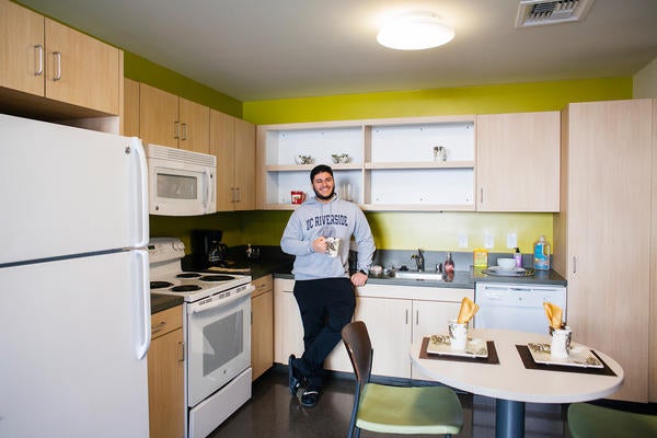 UCR student standing in residence hall kitchenette