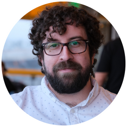 photo of Anthony Shemaria, a UCR student with short, dark curly hair, wearing glasses and smiling at the camera