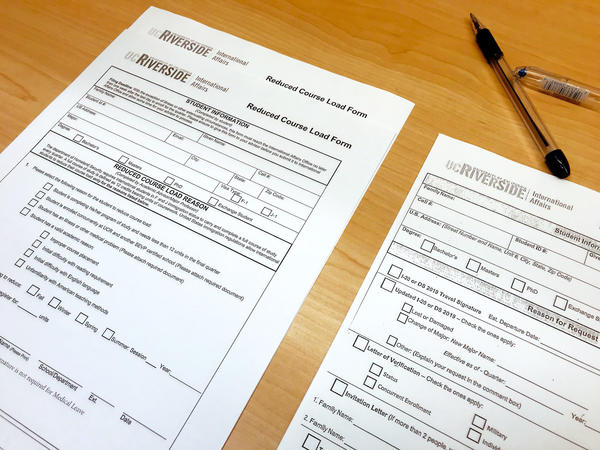 Reduced Course Load Form and Document Request Form laying on a table next to a pen