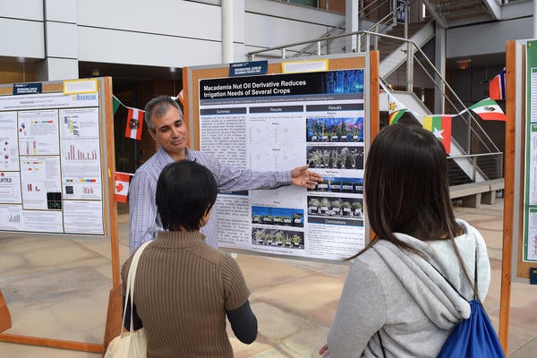 International Scholar displaying research poster