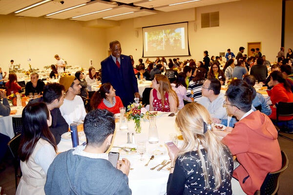 Dr. Kalu greeting students at Thanksgiving event