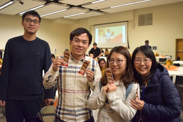 Group of 4 international scholars posing with photobooth film strip