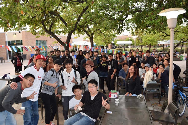 Large group of international students posing outside during ISU coffee hour