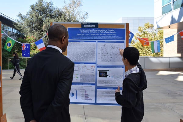 International Scholar displaying research poster