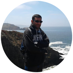 Photo of Rasin Kellow, a UCR student with dark hair who is smiling at the camera with the ocean in the background