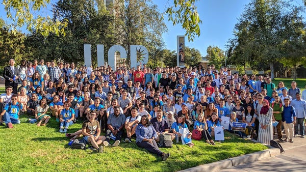 Large group of international students posing in front of UCR letters