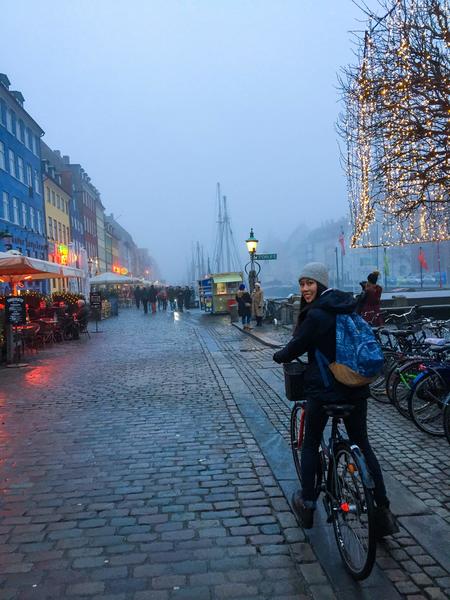 Female UCR student riding bicycle in Copenhagen