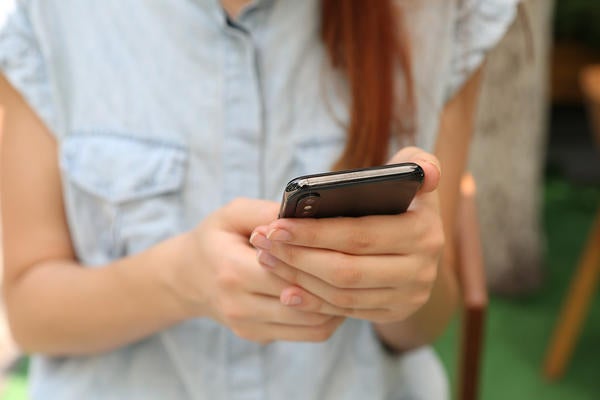 closeup of woman's arms and hands holding cellphone (c) Yura Fresh unsplash