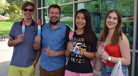 students with popsicles in front of shop