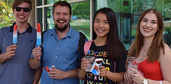 students with popsicles in front of shop