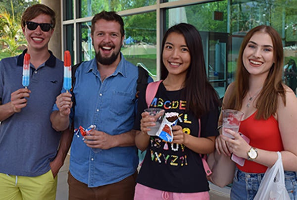 students with popsicles in front of shop