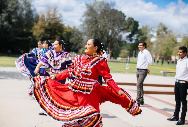 UCR students dancing Ballet Folklorico near belltower