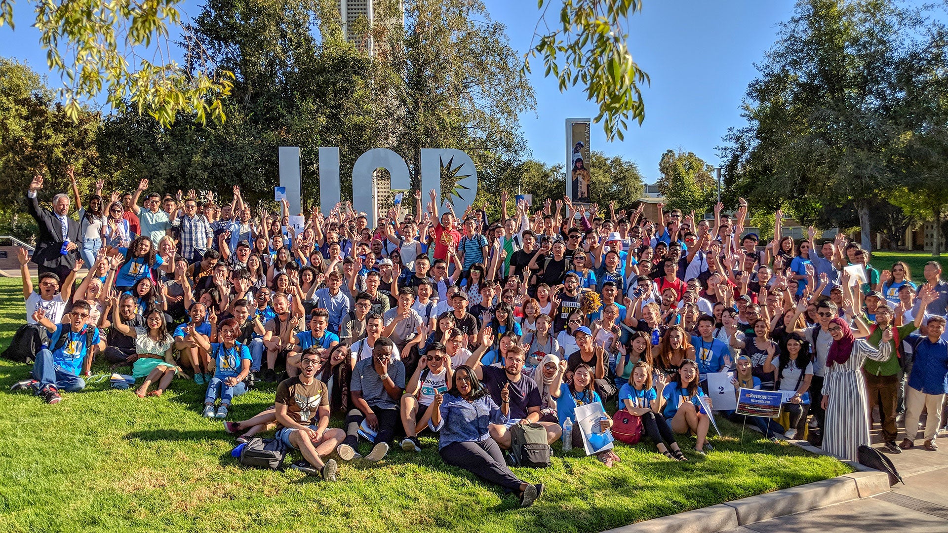 Large group of international students posing in front of UCR letters