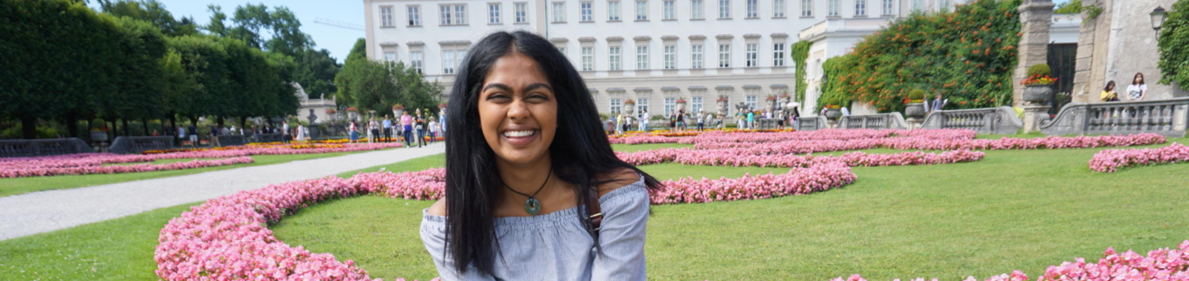 Female UCR student smiling and posing by German landmark